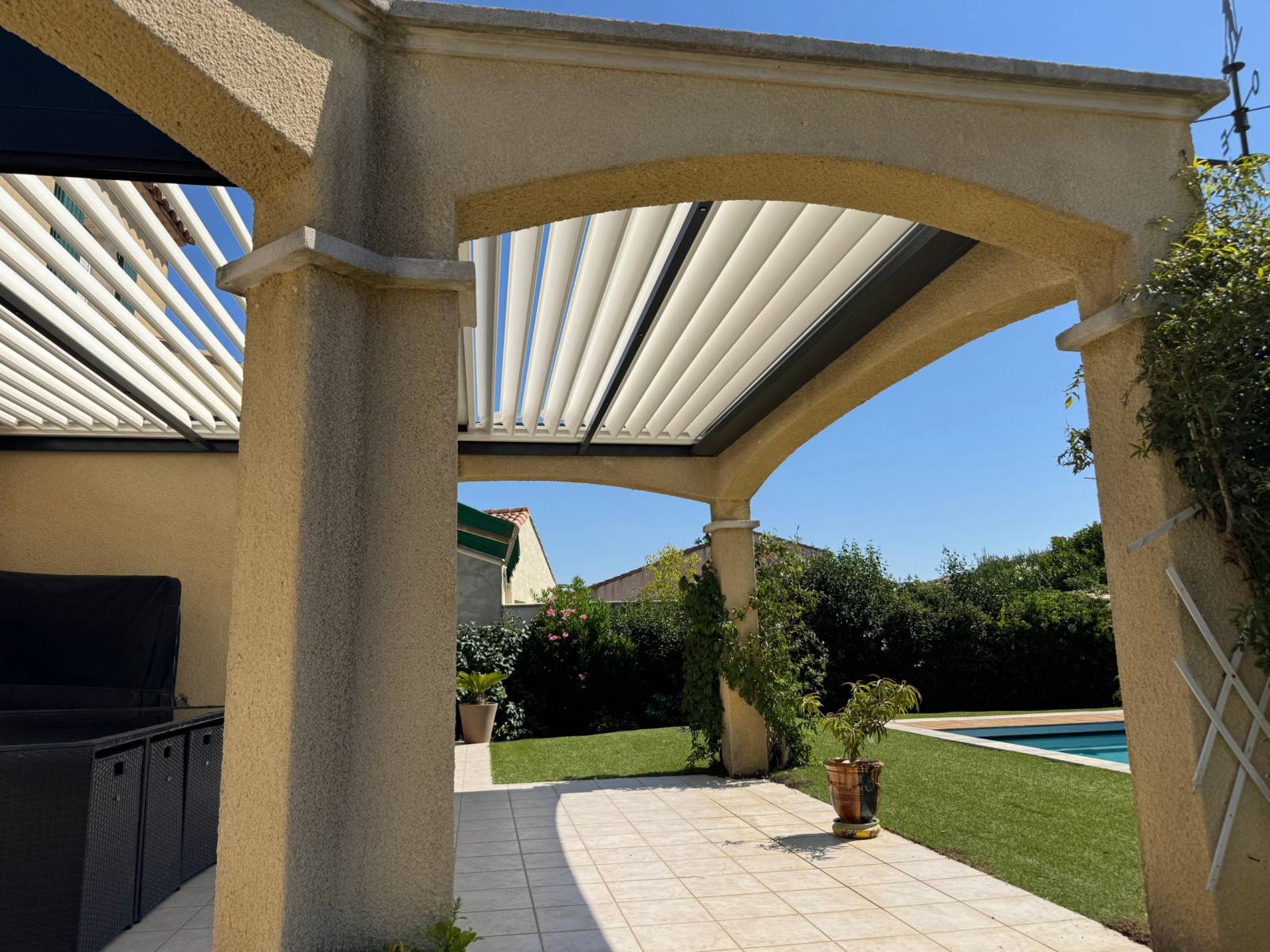 Photo d'une pergola bioclimatique sans poteau gris anthracite fabriquée sur mesure installée à Nîmes dans le Gard