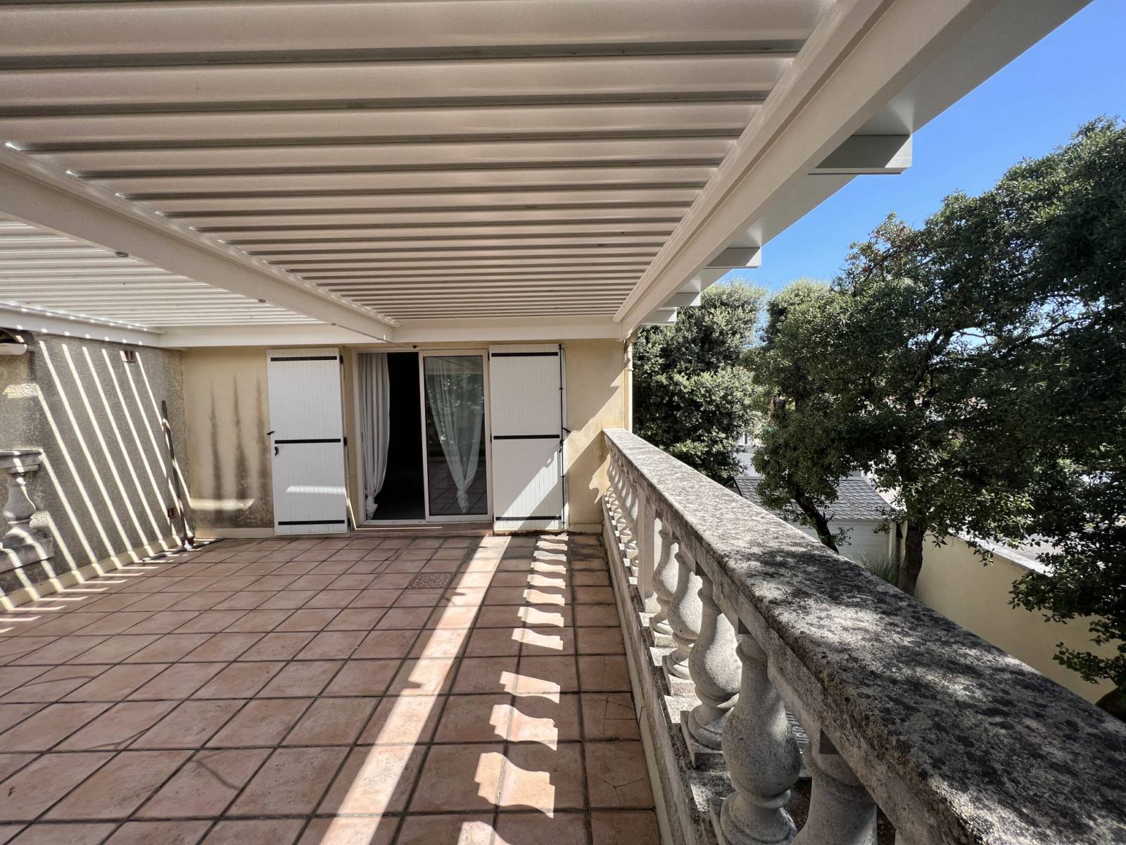 Installation adossée d'une pergola à lames orientables sur mesure sur un toit terrasse à Alès dans le 30