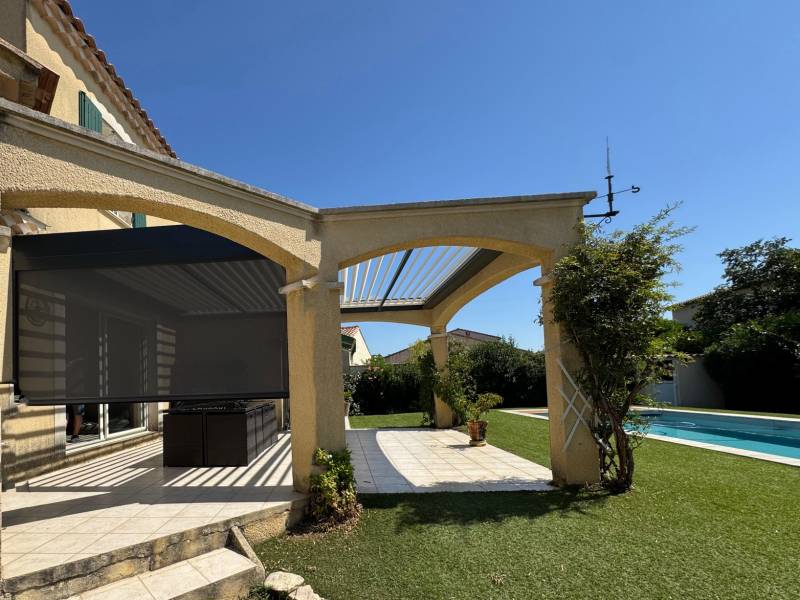 Photo d'une pergola à lames orientables sur mesure avec store zip screen motorisé installée à Nîmes dans le 30