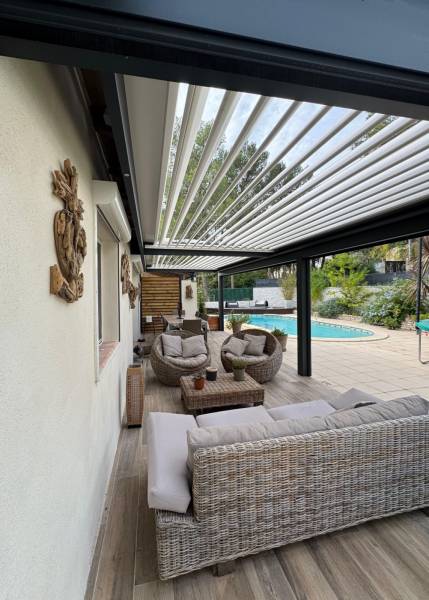 Photo après la pose adossée d'une pergola à lames orientables fabriquée sur mesure à Alès dans le 30 