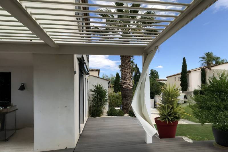Pose adossée d'une pergola bioclimatique sur mesure aluminium blanche à Aigues-Mortes dans le 30