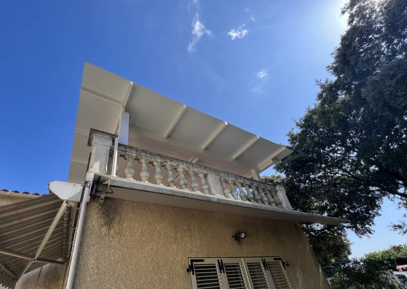 Installation adossée d'une pergola à lames orientables aluminium fabriquée sur mesure à Alès dans le Gard