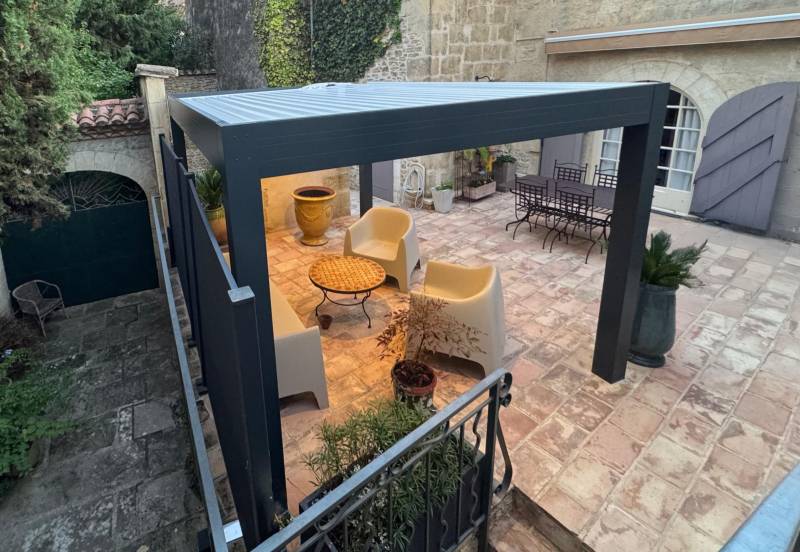 Photo d'une pergola autoportée design gris anthracite à lames orientables à Alès dans le Gard
