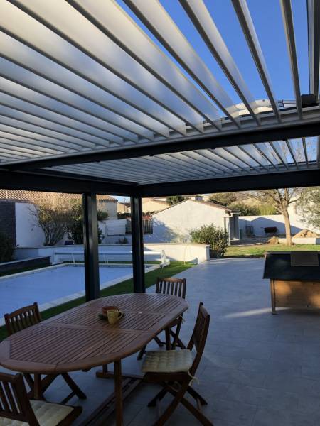 Implantation d'une pergola bioclimatique aluminium sur mesure 7X4 sur une terrasse avec pose adossée à Redessan dans le Gard