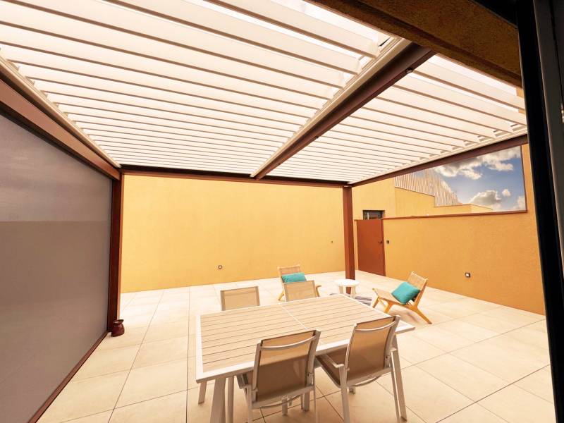 Vue intérieure d'une pergola bioclimatique alu fabriquée sur mesure et installée à Montpellier dans le 34