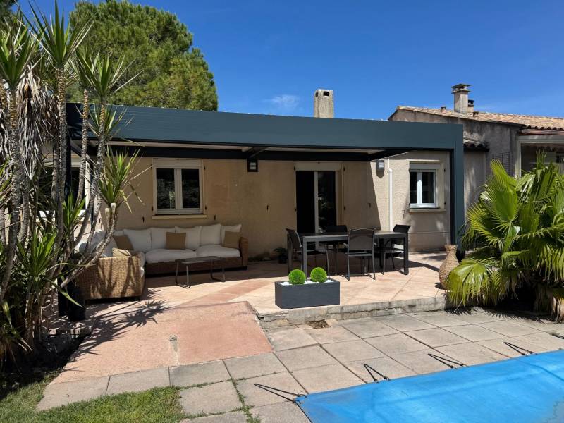 Vue de face d'une pergola bioclimatique alu 3X6 adossée conçue et installée sur mesure à Montpellier dans l'Hérault