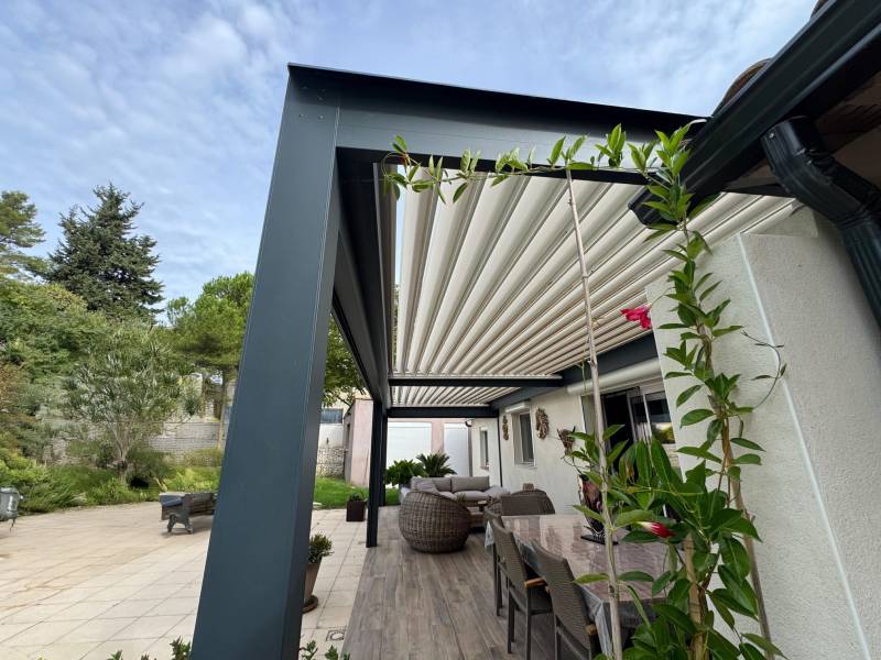 Design gris anthracite et blanc pour cette pergola bioclimatique conçue et fabriquée sur mesure à Alès dans le 30