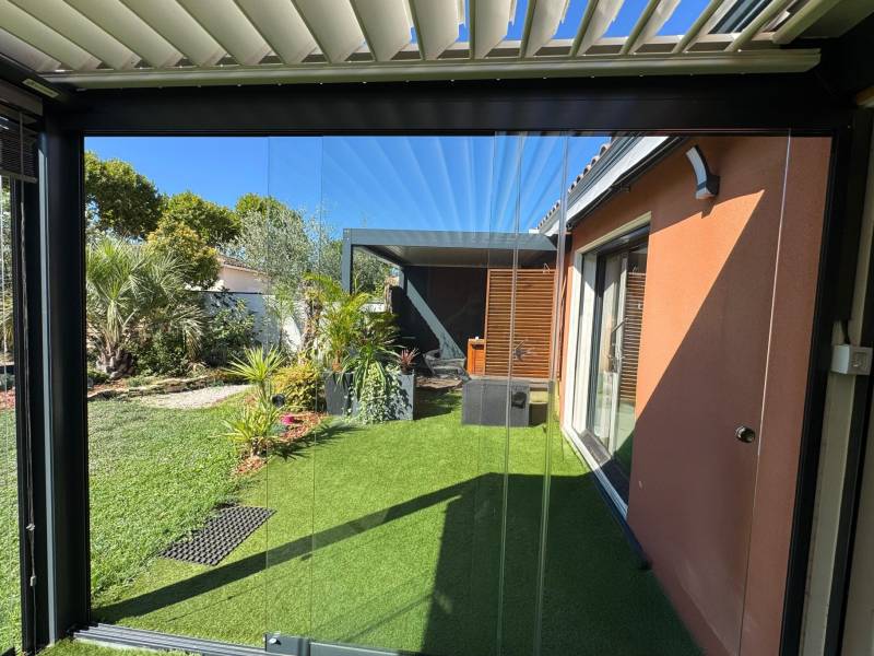 Exemple de pose de parois de verre coulissantes pour fermer une pergola bioclimatique à Villevieille dans le 30