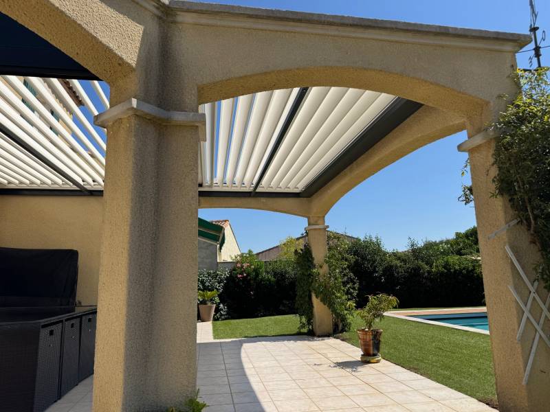 Photo d'une pergola bioclimatique sans poteau gris anthracite fabriquée sur mesure installée à Nîmes dans le Gard