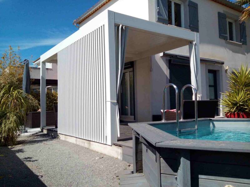 Réalisation d'une pergola bioclimatique blanche avec brise vue bouclier à Aigues-Mortes dans le Gard