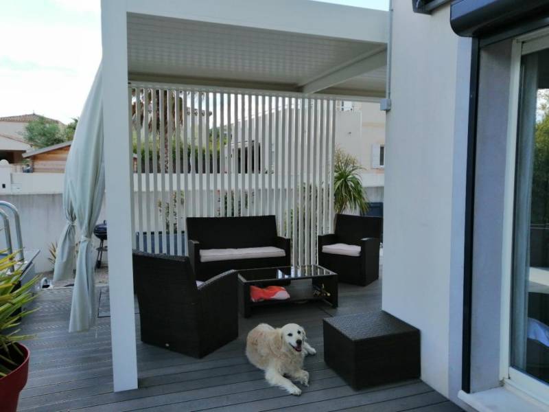 Installation adossée d'une pergola bioclimatique blanche sur mesure à Aigues-Mortes dans le 30