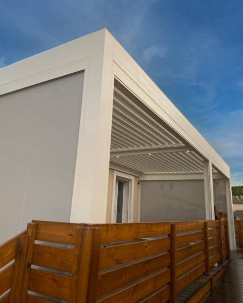 Pose adossé d'une pergola bioclimatique aluminium sur mesure blanche à Caveirac dans le 30