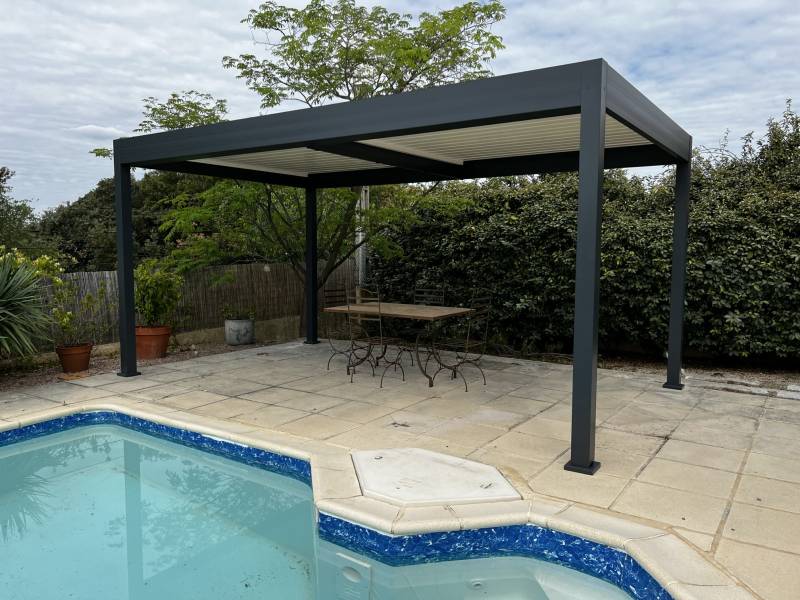 Pose d'une pergola bioclimatique autoportante sur mesure sur une plage de piscine à Alès dans le 30