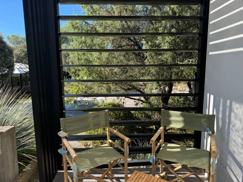 Conception sur mesure d'un brise vue à lames orientables installé sur la partie latérale d'une pergola à Villevieille dans le 30