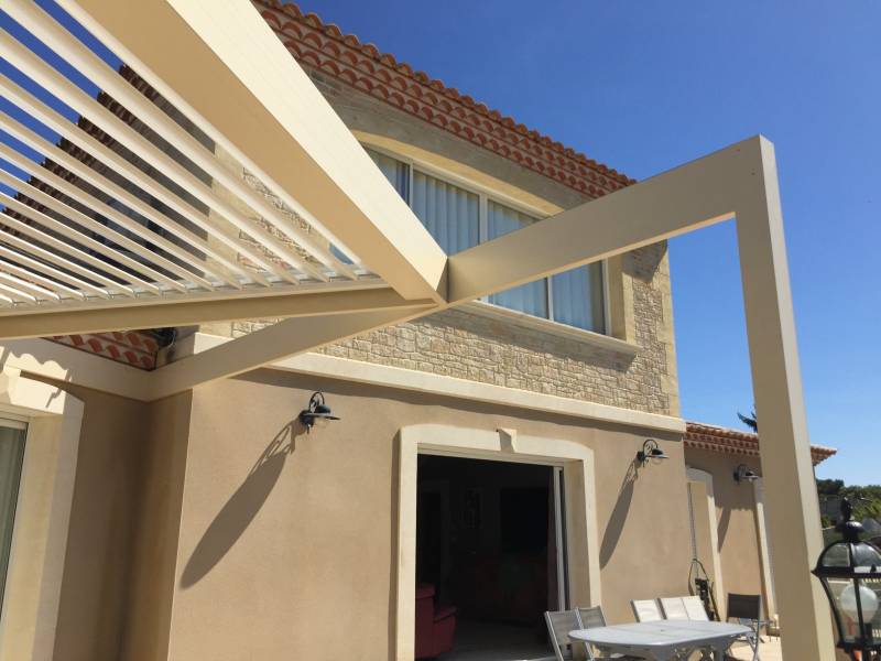 Photo d'une pergola à lames orientables design fabriquée sur mesure pose adossée à Congénies dans le 30