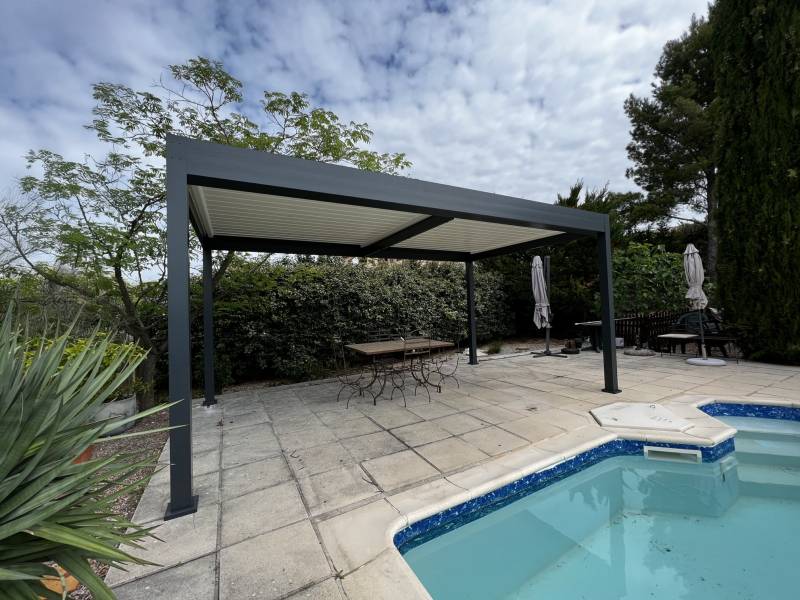 Aménagement d'une plage de piscine avec l'installation d'une pergola à lames orientables autoportée sur mesure à Alès dans le Gard