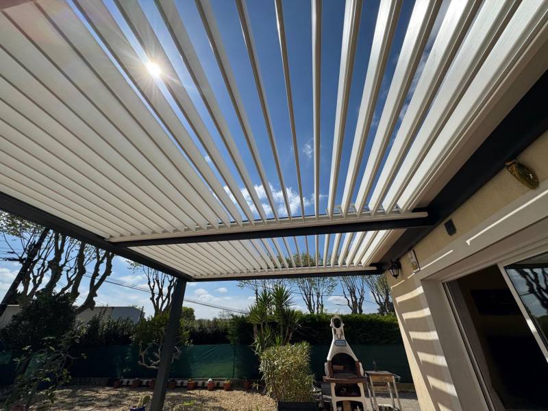 Réalisation d'une pergola bioclimatique à lames orientables avec poteau déporté adossée deux murs à Montpellier 34