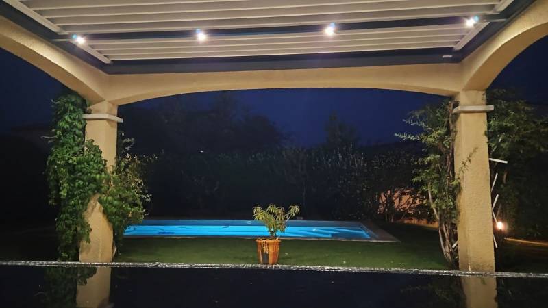Pose entre murs d'une pergola bioclimatique sans poteau moderne à Nîmes dans le 30