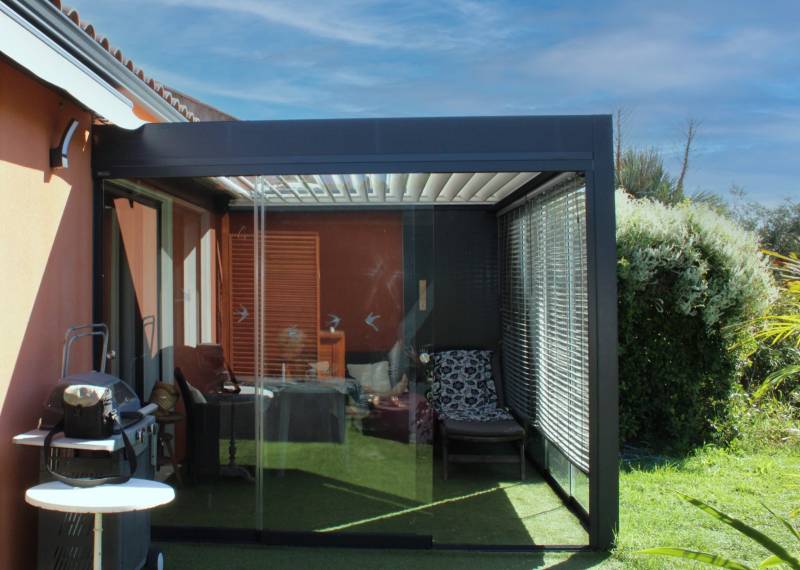 Fermeture d'une pergola bioclimatique par panneaux de verre coulissants panoramiques à Villevieille dans le 30