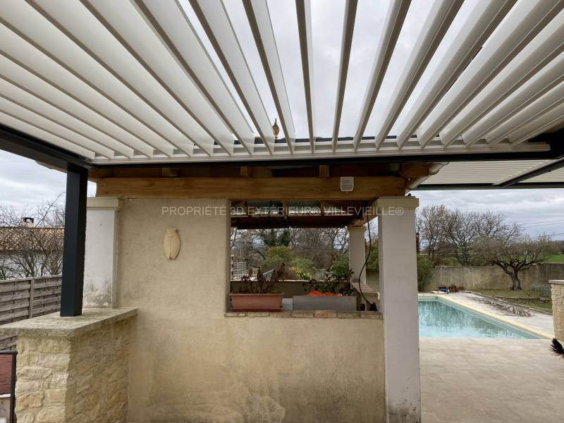 La pergola assure une protection solaire efficace en créant un ombrage et une fraîcheur simplement en entrouvrant les lames orientables aménagement sur Aubussargues dans le Gard (30)
