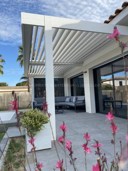 Pergola bioclimatique blanche de dimension standard installée à Villevieille dans le Gard