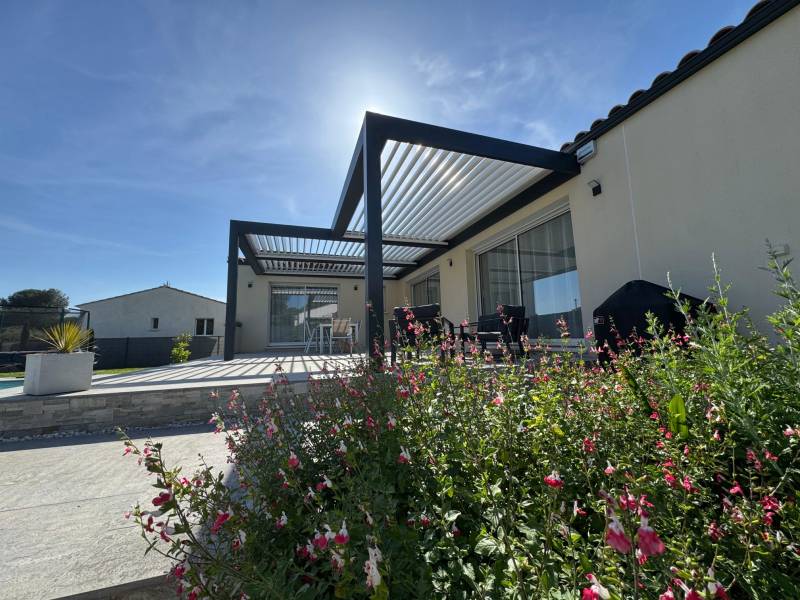 Exemple de pergola bioclimatique alu sur mesure adossée à Nîmes dans le Gard