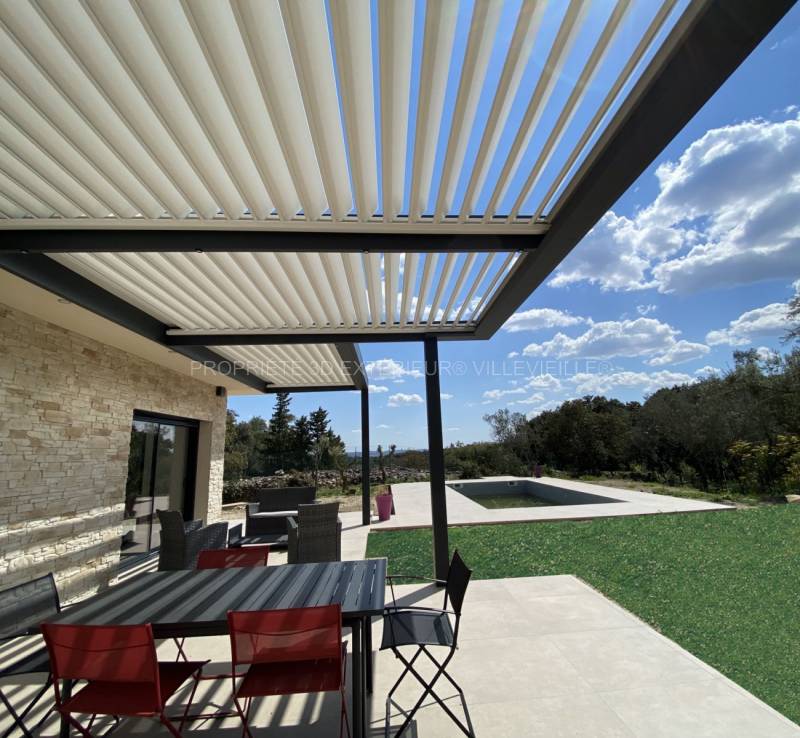 Pergola en aluminium sur mesure réalisation de fabrication française adossée à la façade d’une maison contemporaine située à Nimes dans le Gard confort et élégance garantie