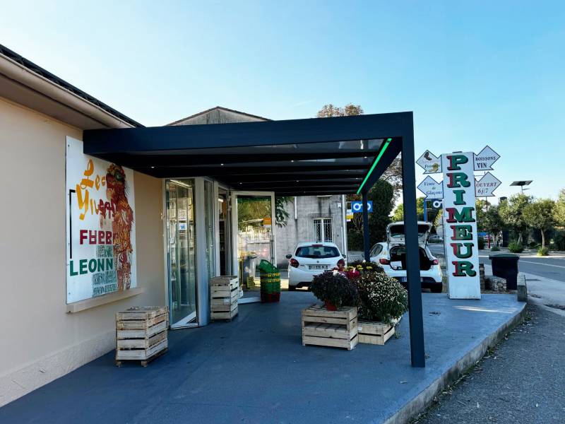 Création d’une pergola en aluminium toiture fixe sur mesure pour une épicerie à Sommières (30).