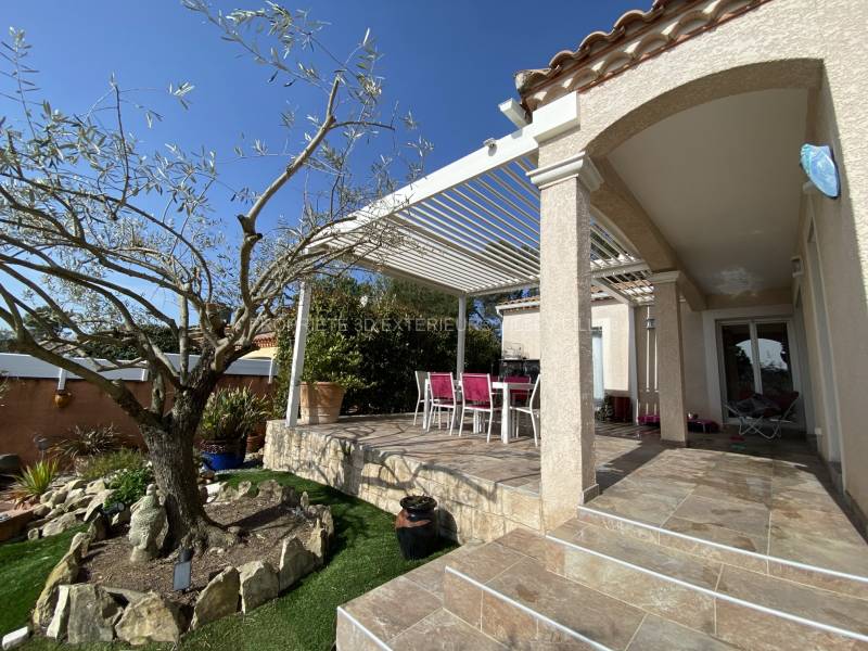 Réalisation d’une pergola bioclimatique adossée structure et lames orientables couleur blanc (ral 9010) implanté dans le village de Vérargues proche de lunel dans l'Hérault en Occitanie